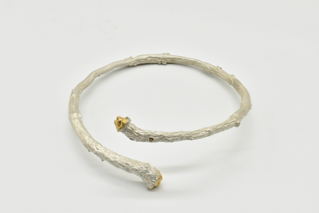 Plata, oro amarillo en extremos y diamante incrustado (400€)